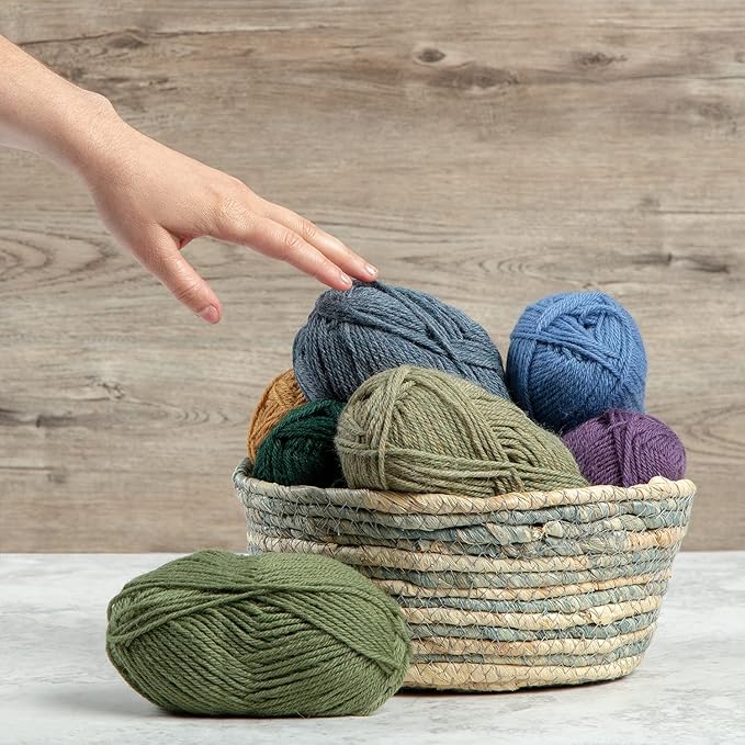A hand touching the basket of Knit Picks Wool Worsted Weight Yarn