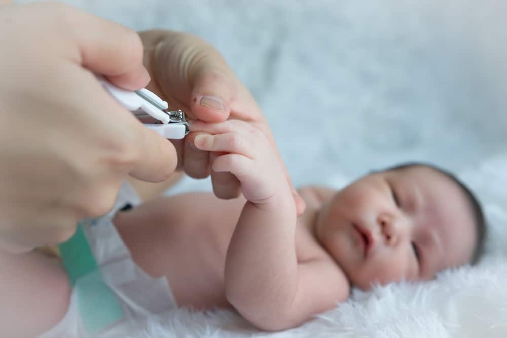 Close up of mother cutting babies nails.