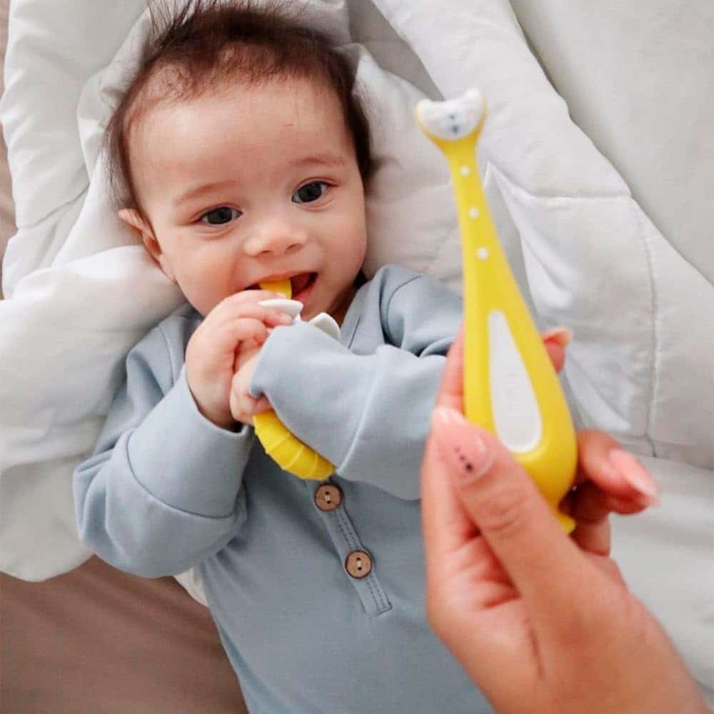 baby using Frida Baby Grow with Me Baby Toothbrush Training Set​