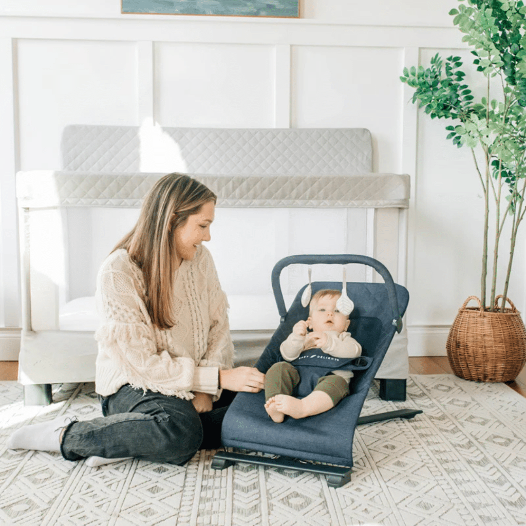 a mom playing with her baby in Delight Alpine Deluxe Bouncer