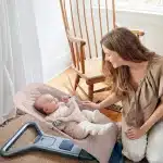 mom playing with her baby in a bouncer