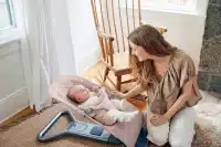 mom playing with her baby in a bouncer