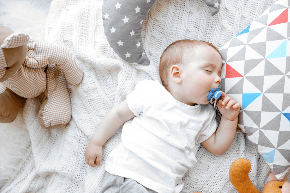 Cute sleeping baby boy with pacifier in his mouth
