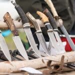 Different types of knives inserted inside a wooden log