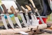 Different types of knives inserted inside a wooden log