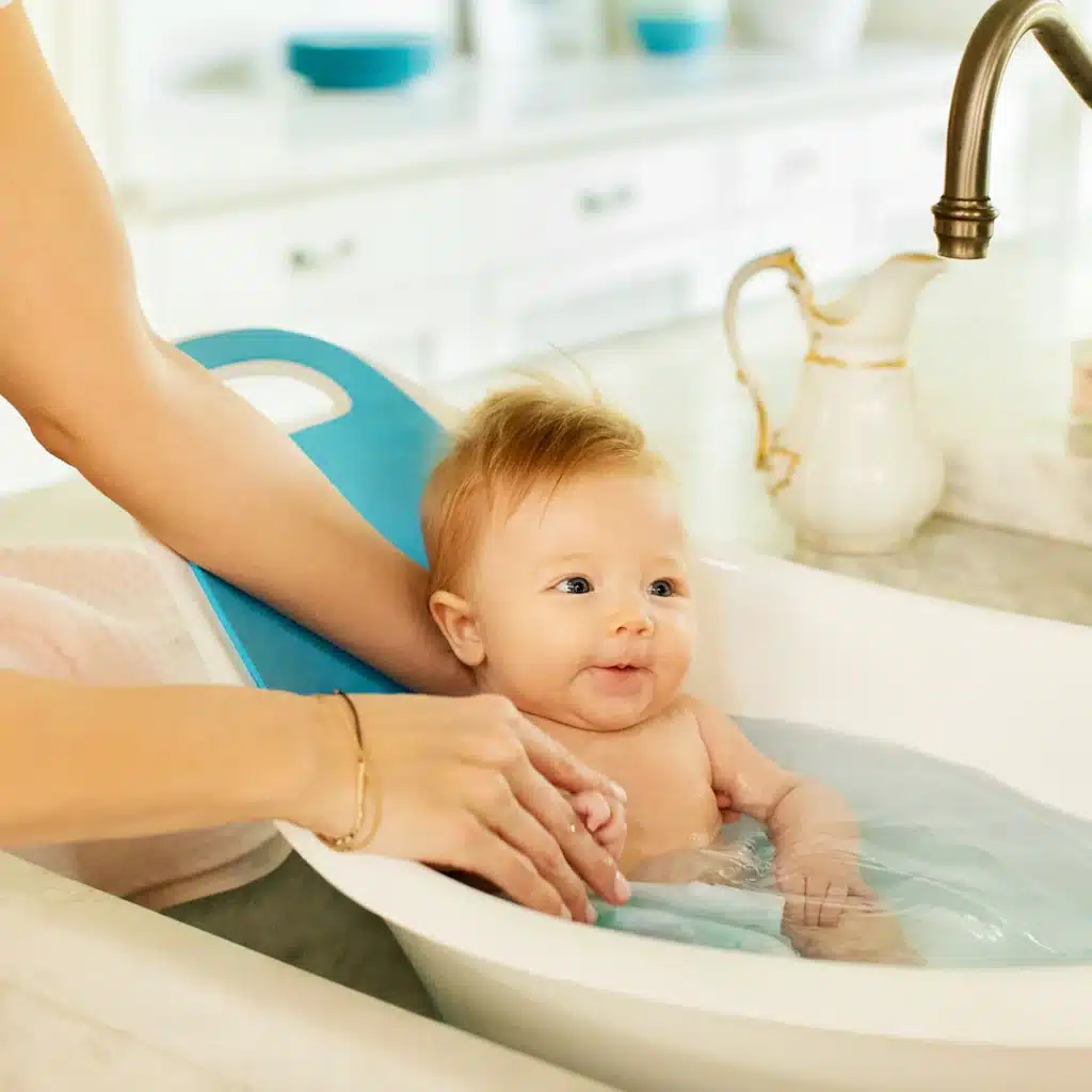 Closeup of a baby showering in Munchkin® Sit Soak™ Baby Bath Tub