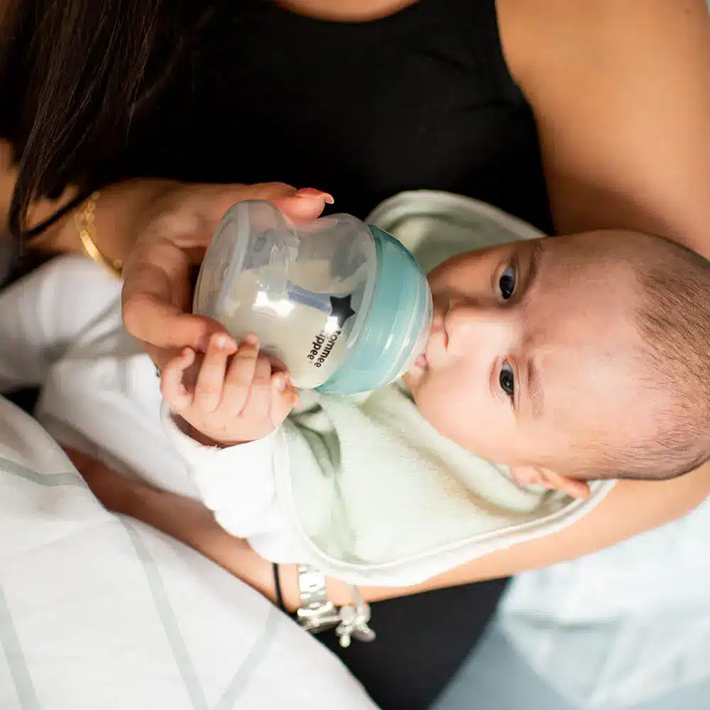 a baby drinking milk from Tommee Tippee Anti Colic Bottle