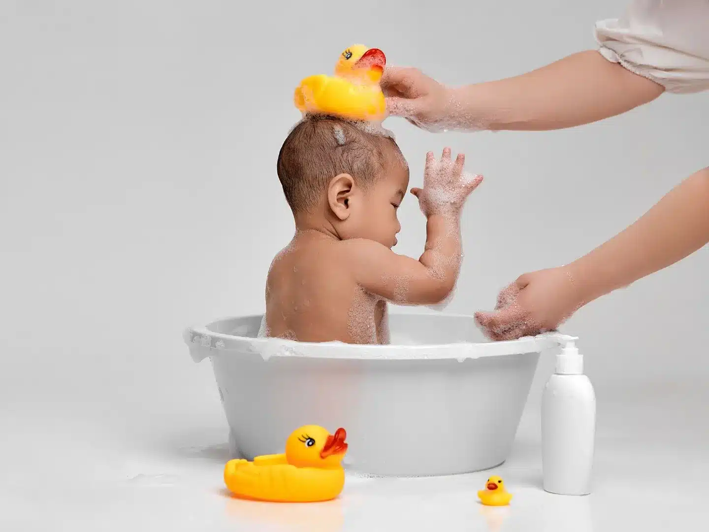 a baby sitting in a baby tub and showering