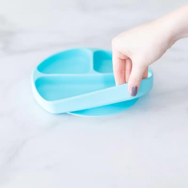 a female hand holding Bumkins Toddler and Baby Suction Plate