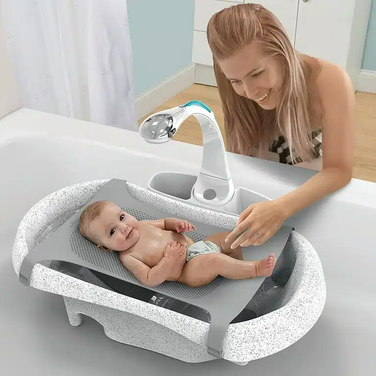 a mom showering her baby in First Year Rain Shower Baby Bath Tub Set