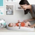 baby in a changing pad mom looking at her baby