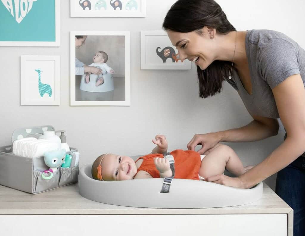 baby in a changing pad mom looking at her baby