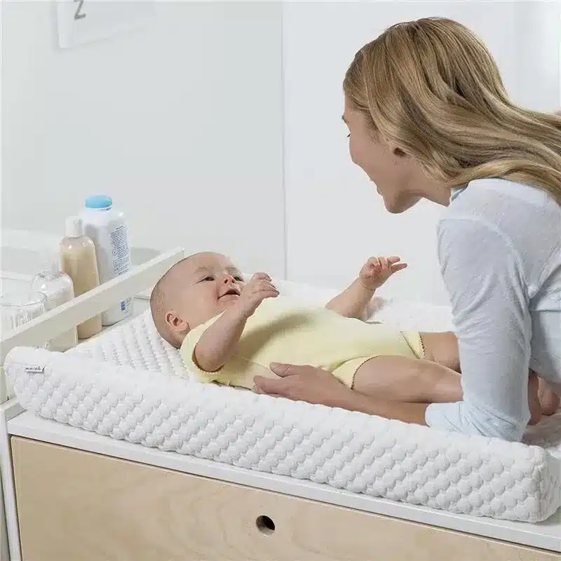 baby lying on Munchkin Secure Grip Baby Changing Pad looking at mom