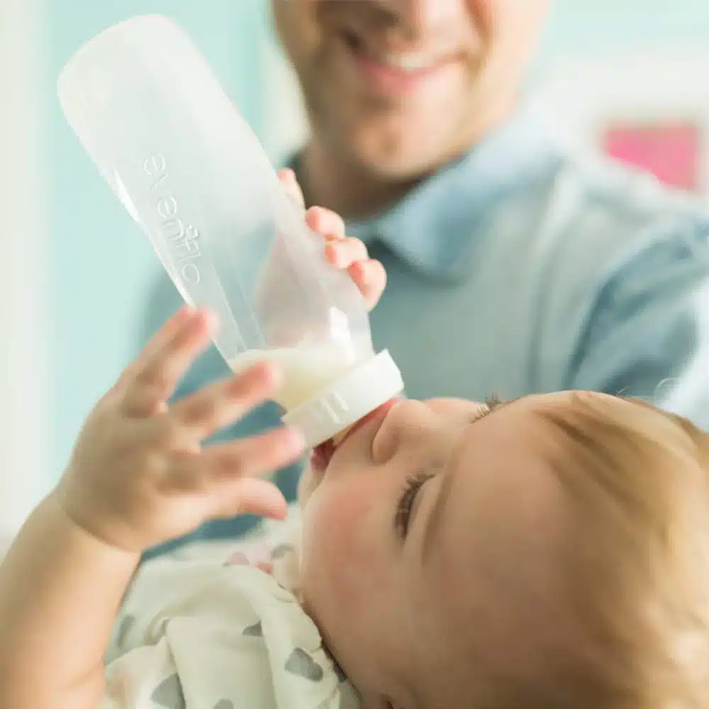 clsoe up of a baby using Evenflo Feeding Classic Tinted Bottles