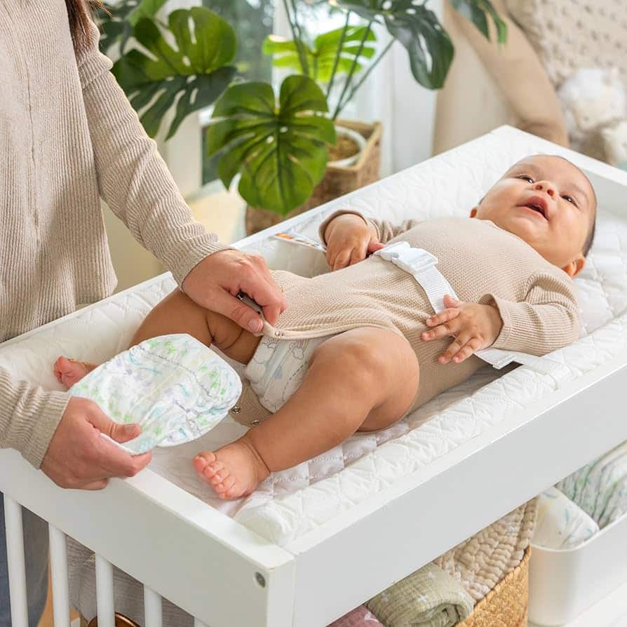 zoomed view of a mom s hands changing baby diaper in Summer by Ingenuity Contoured Changing Pad