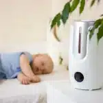 humdifier placed on side table baby sleeping in background
