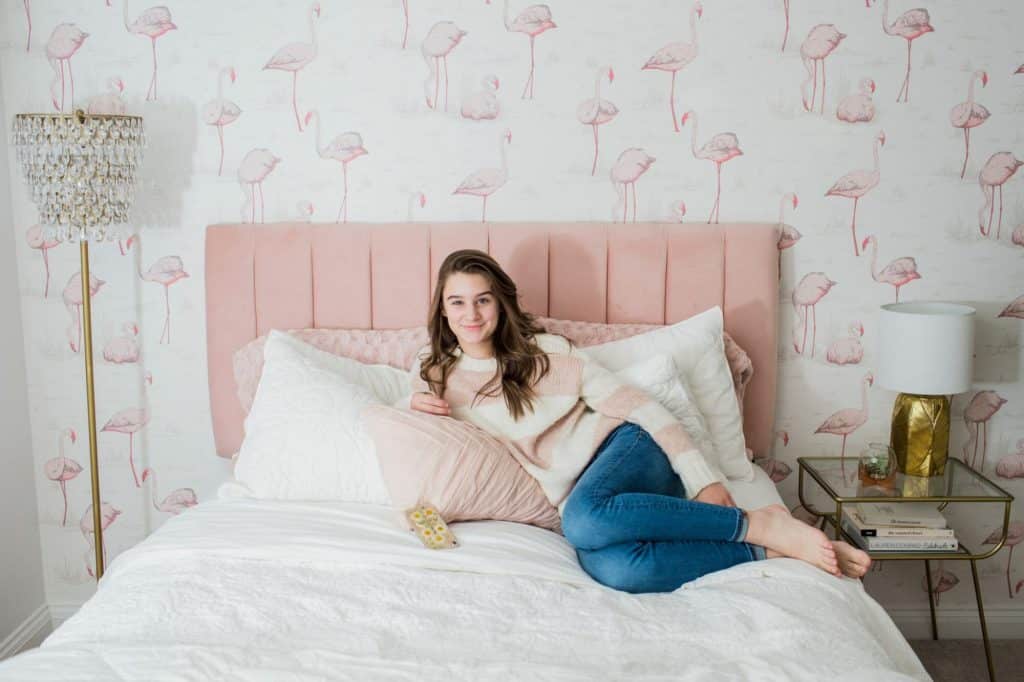 A view of a girl sitting on a bed