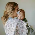 Woman holding baby over shoulder with floral burp cloth