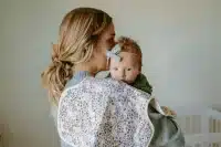 Woman holding baby over shoulder with floral burp cloth