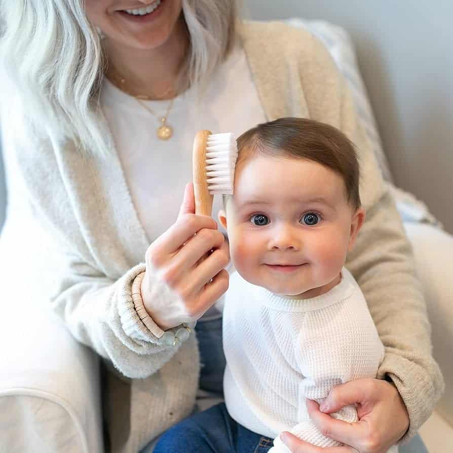 a mom combing baby s hair with Dr Brown s Soft and Safe Baby Brush
