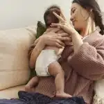 a mother holding her baby wearing a diaper