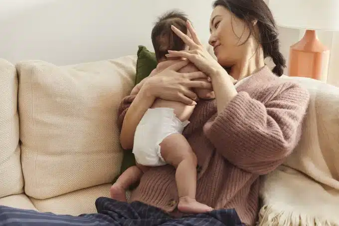a mother holding her baby wearing a diaper