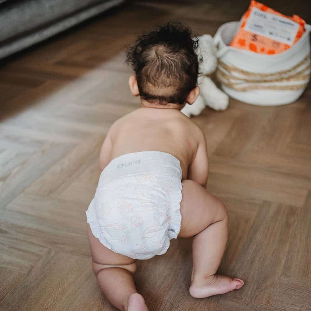 back of a baby crawling on floor wearing Pura Hypoallergenic Diaper