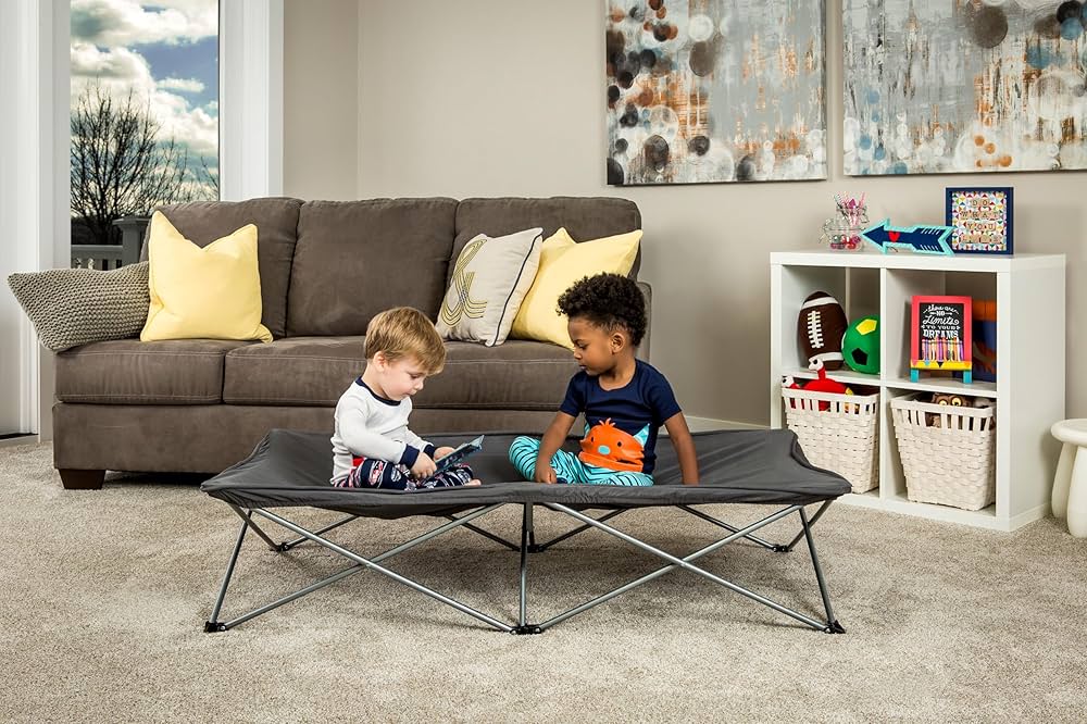cute kids sitting on a tollder cot placed in a living room