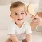 mom brushing baby hair with a brush