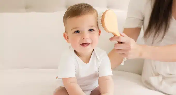 mom brushing baby hair with a brush
