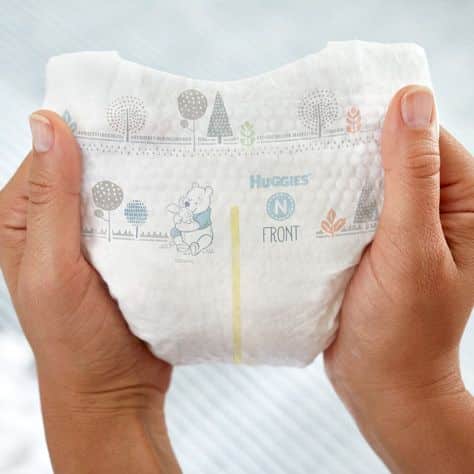 zoomed view of hands holding huggies diaper