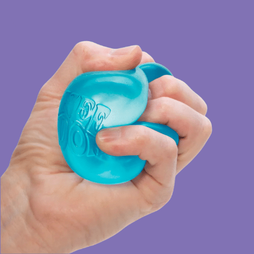 A hand holding Schylling NeeDoh Nice Cube isolated on a purple background