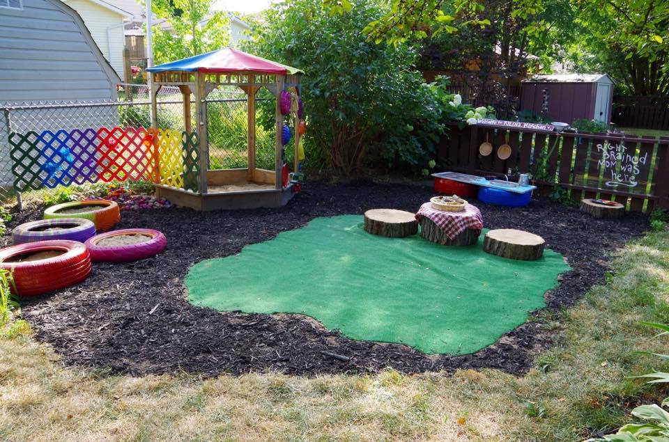 Backyard play area with gazebo painted tires stump seats and mud kitchen