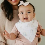 a baby girl wearing a cute bib