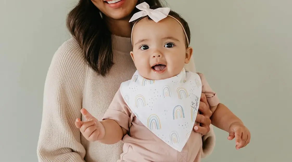 a baby girl wearing a cute bib