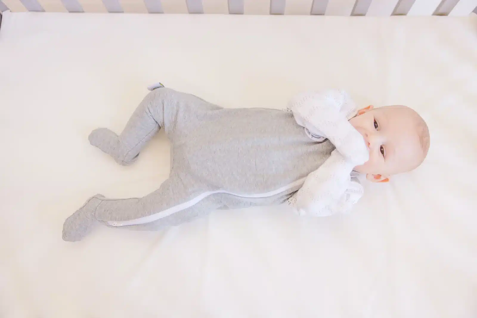 cute baby wearing a gray colored baby footies