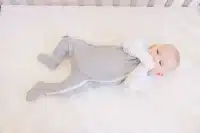 cute baby wearing a gray colored baby footies