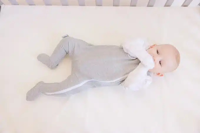 cute baby wearing a gray colored baby footies
