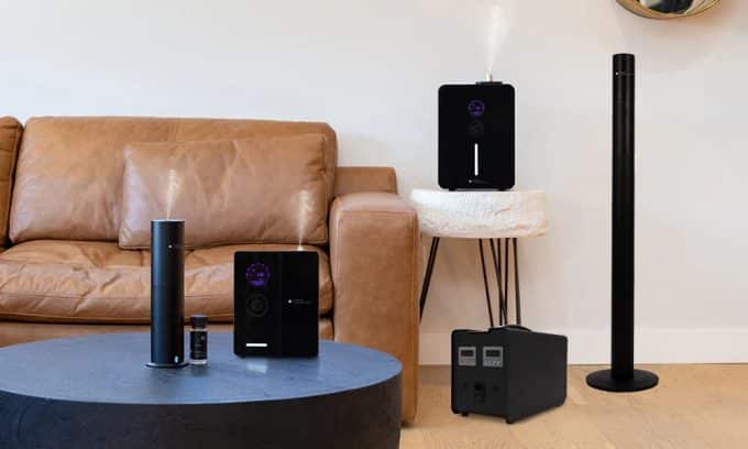 A modern living room with a black air purifier essential oil diffuser and a second air purifier in the background zon