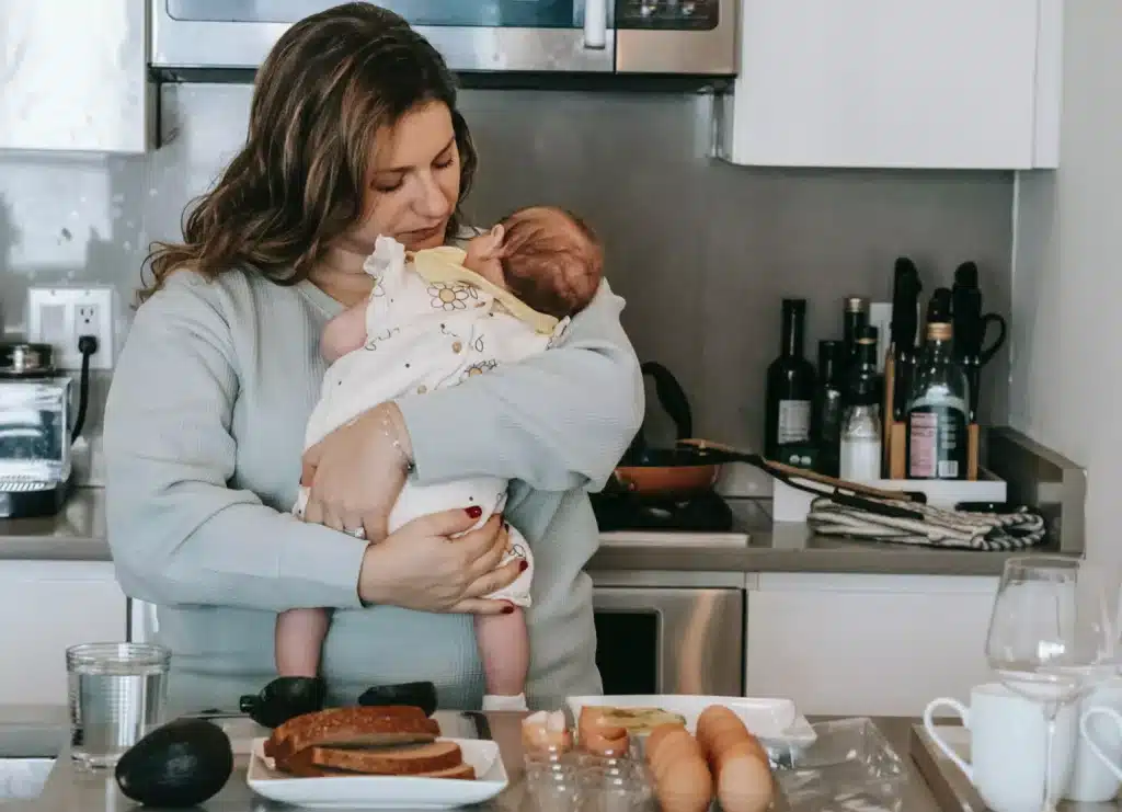 a new mom holding her newborn bread and eggs infront of her