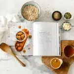 postpartum recipe book oatmeal in a bowl and a few snacks in small bowls placed on a countertop
