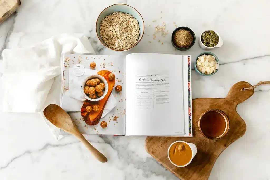 postpartum recipe book oatmeal in a bowl and a few snacks in small bowls placed on a countertop