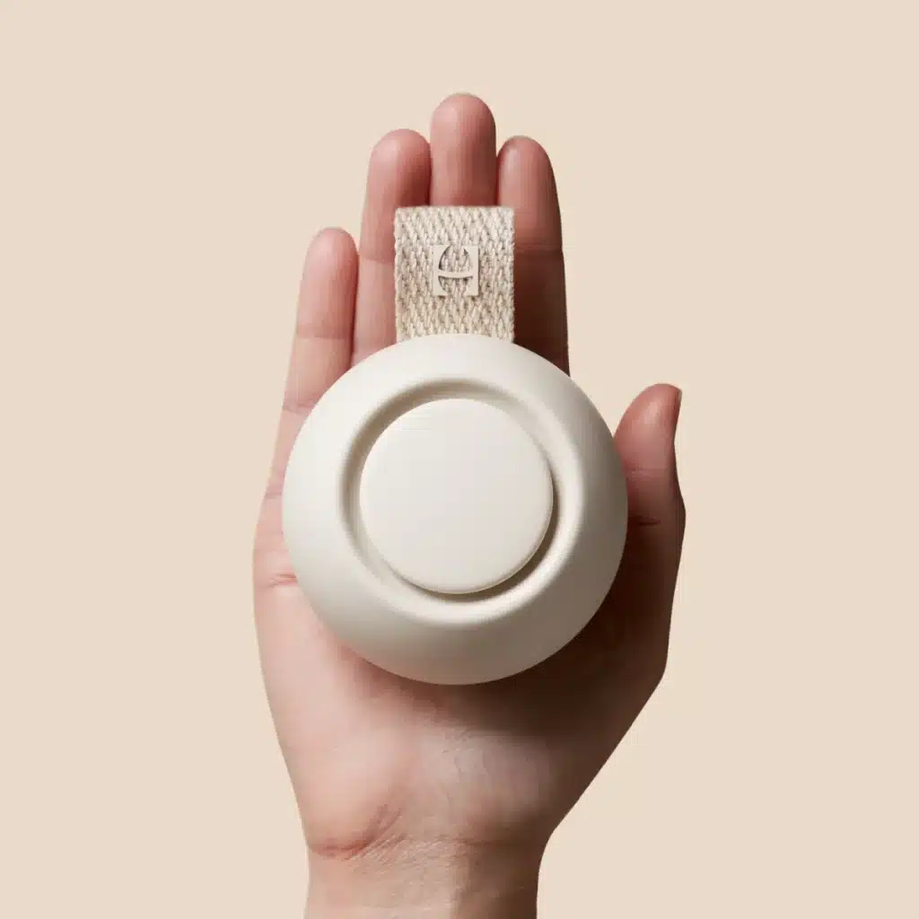 zoomed in view of a hand holding Hatch Rest Portable Sound Machine